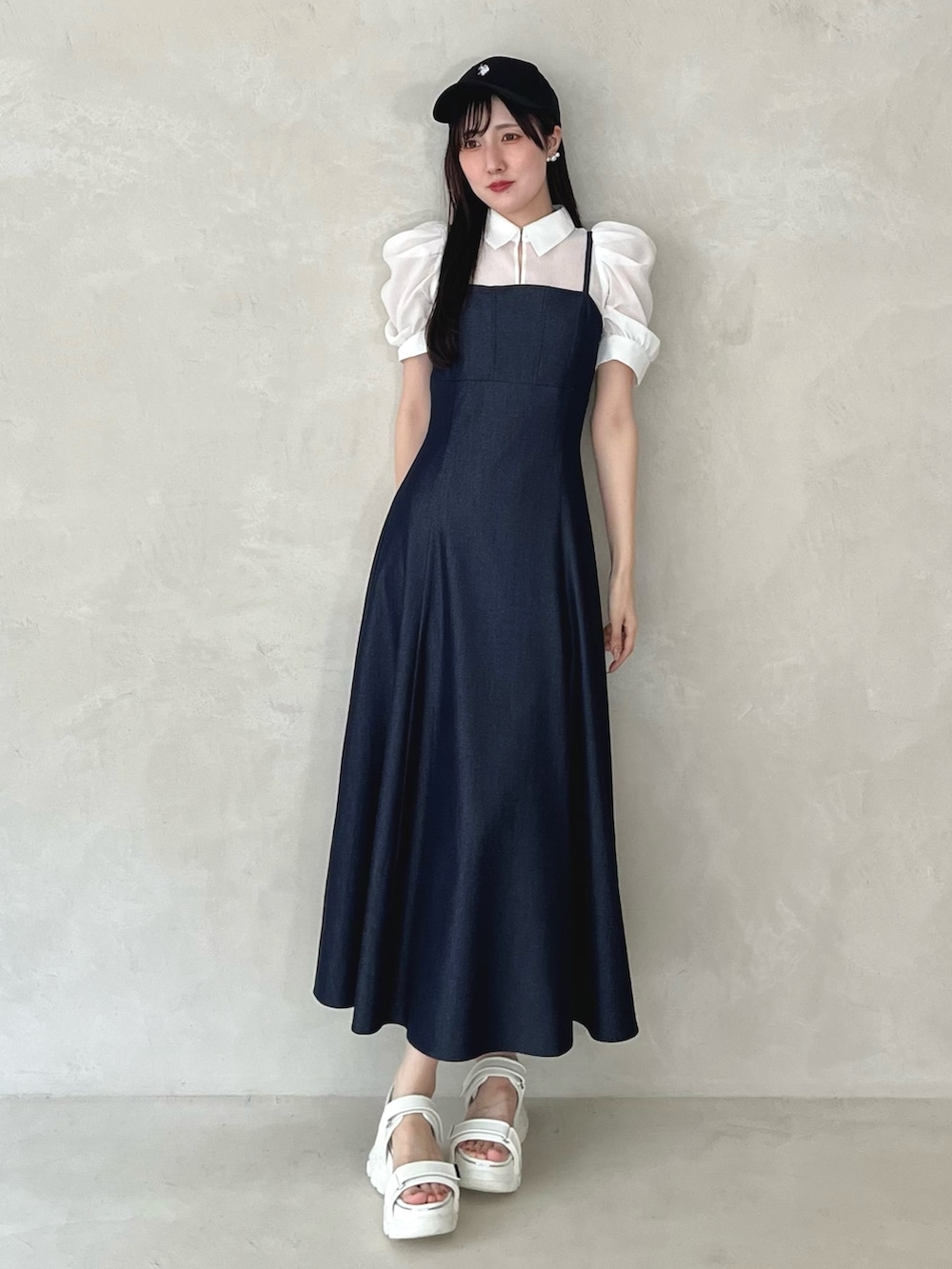 ホワイト系のサンダル、ブルー系のワンピース、ブラック系のキャップを着用したレディースの夏コーディネートの2枚目の写真