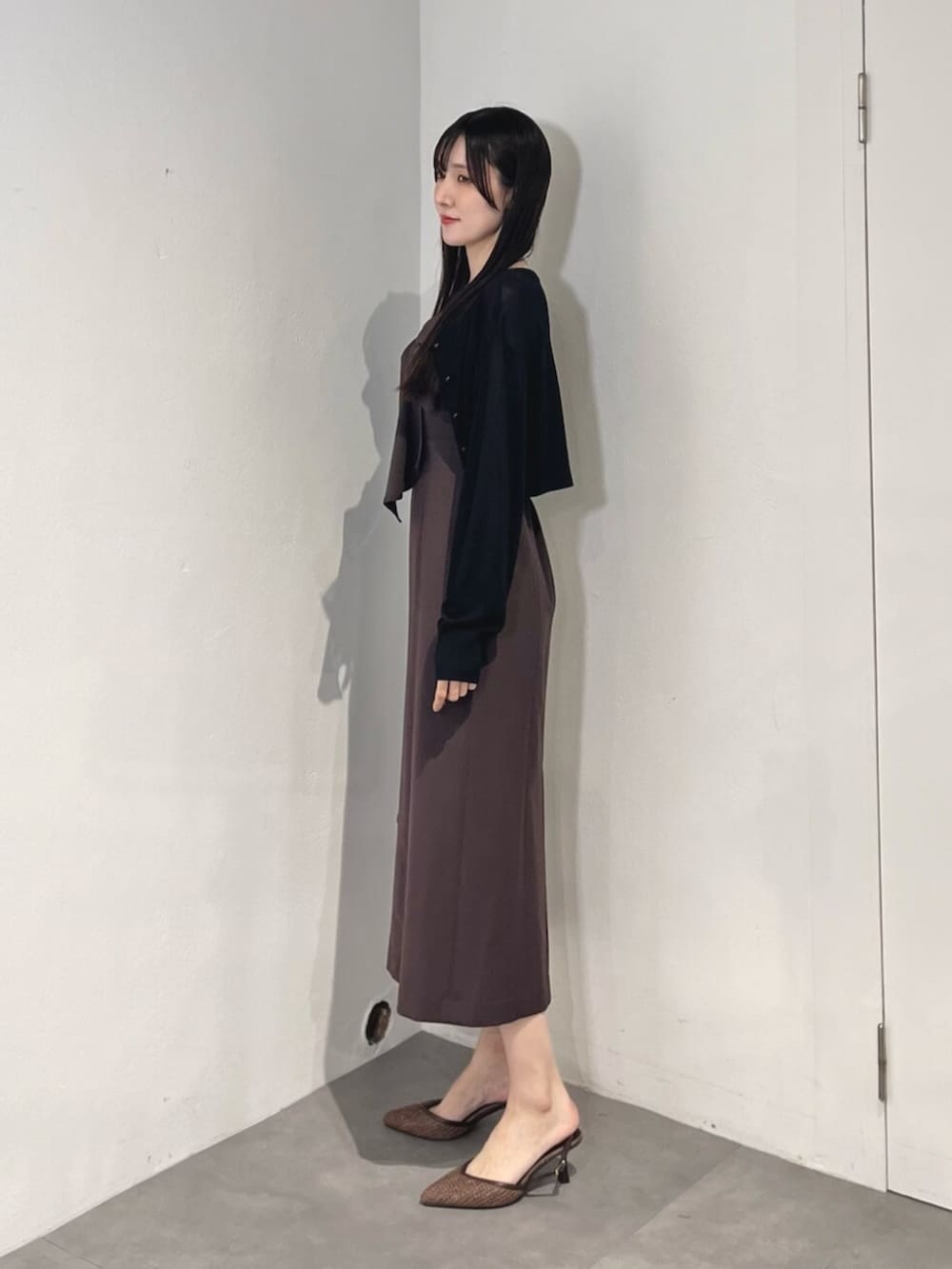 ブラウン系のハンドバッグ、ブラウン系のパンプス、ブラック系のカーディガン/ボレロを着用したレディースの夏コーディネートの3枚目の写真