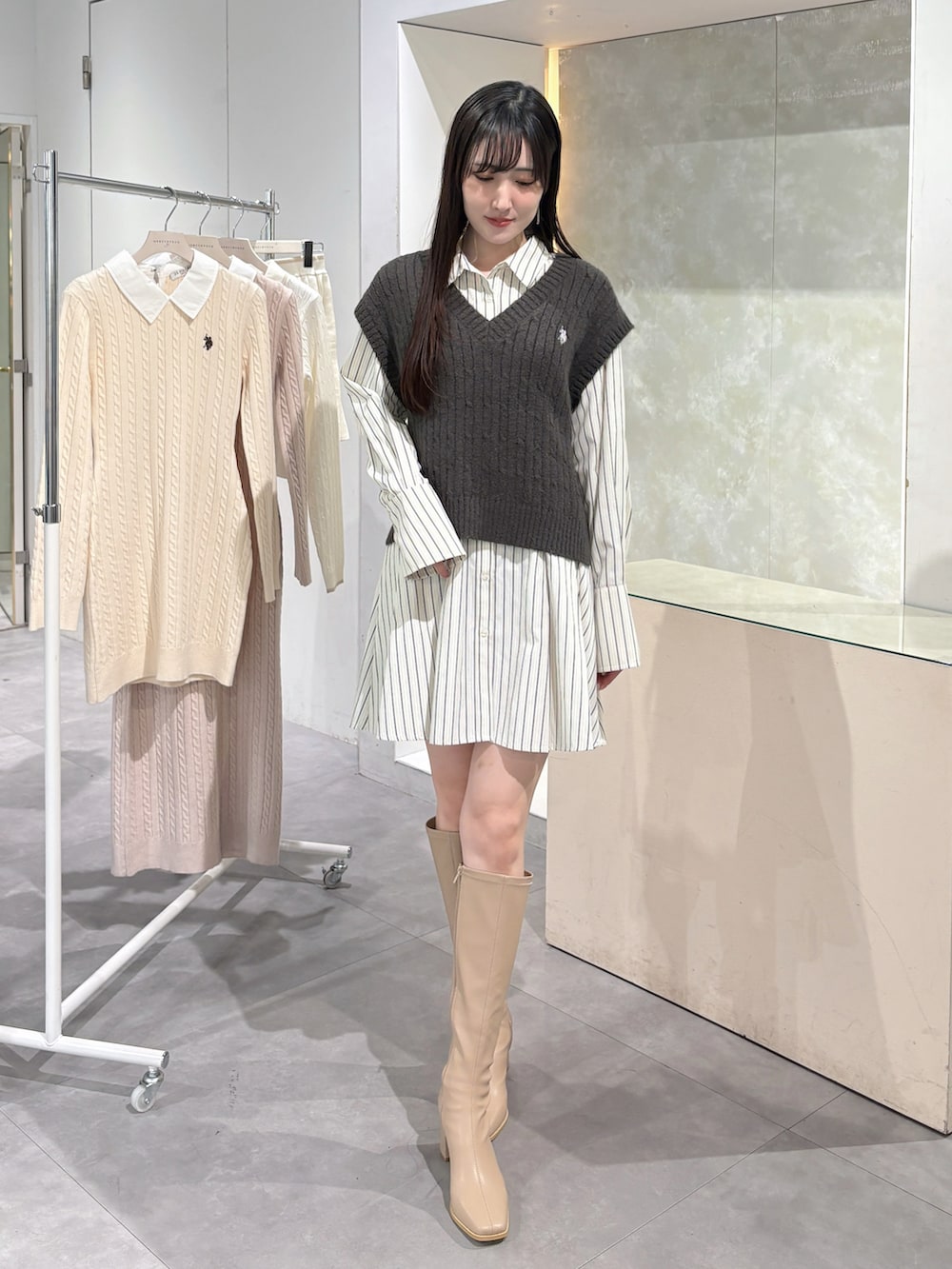 グレー系のワンピース、ベージュ系のブーツを着用したレディースの冬コーディネートの2枚目の写真