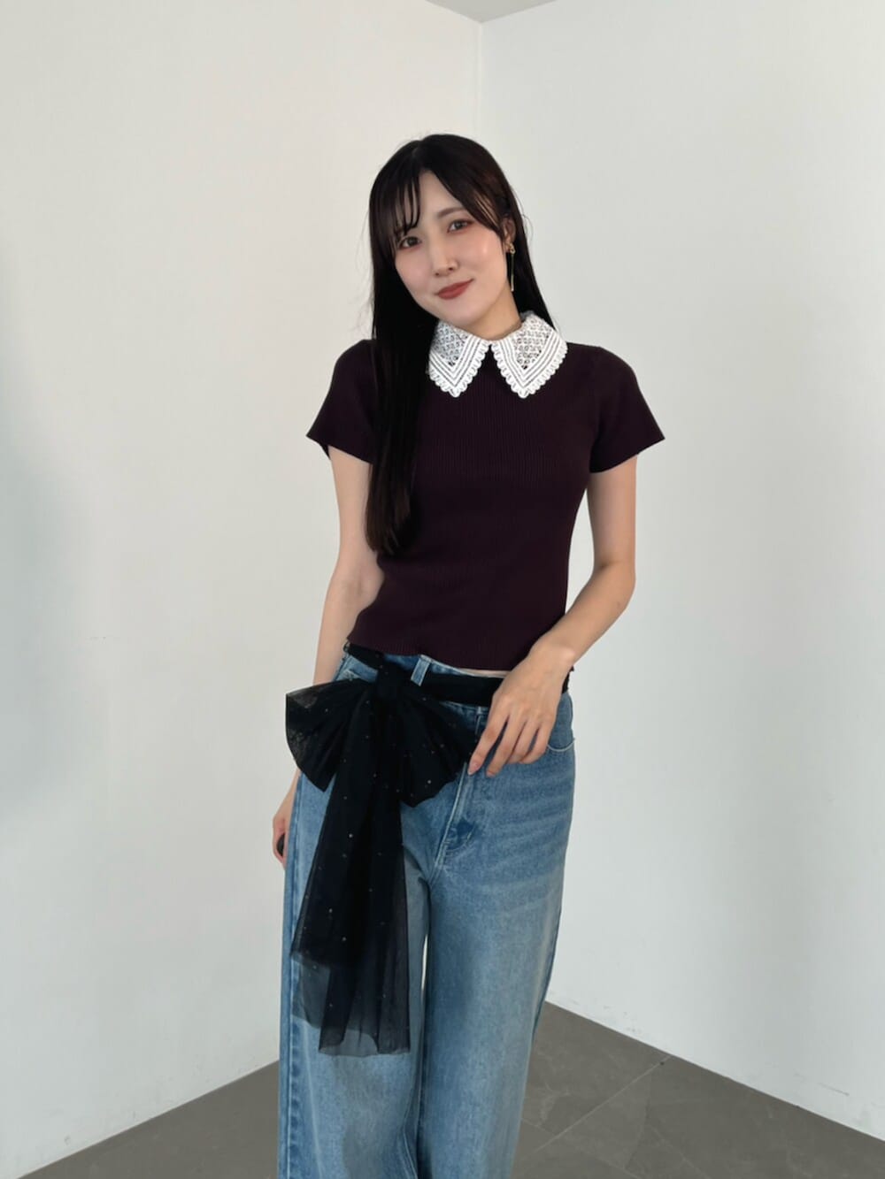 ブラウン系のニット/セーター、ブラウン系のローファー、ブルー系のデニムパンツを着用したレディースの夏コーディネートの4枚目の写真