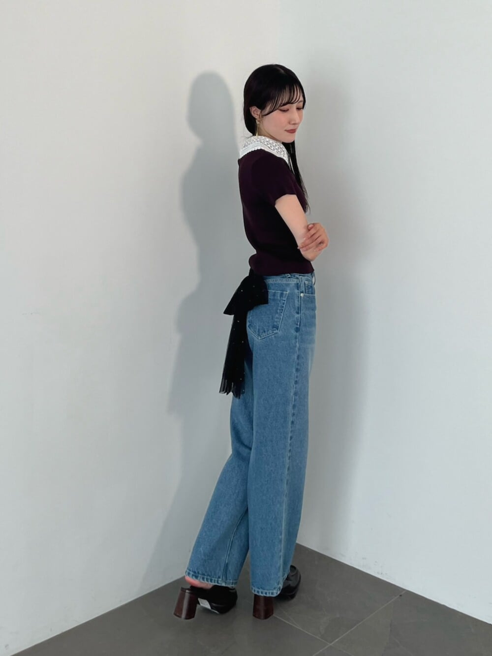 ブラウン系のニット/セーター、ブラウン系のローファー、ブルー系のデニムパンツを着用したレディースの夏コーディネートの9枚目の写真