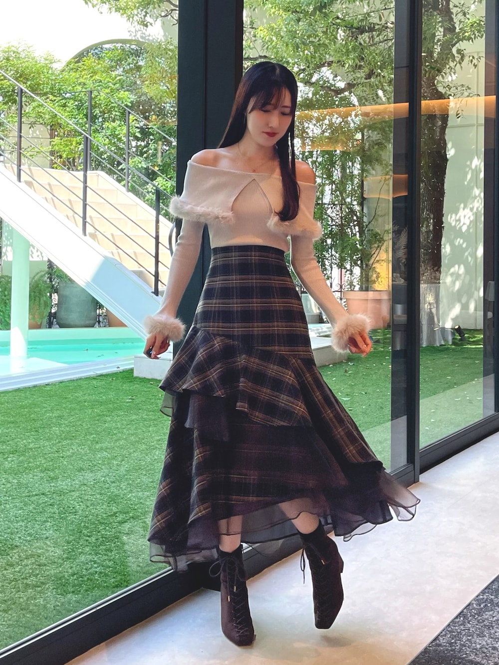 ブラウン系のブーツ、グレー系のスカート、ベージュ系のニット/セーターを着用したレディースの秋コーディネートの3枚目の写真