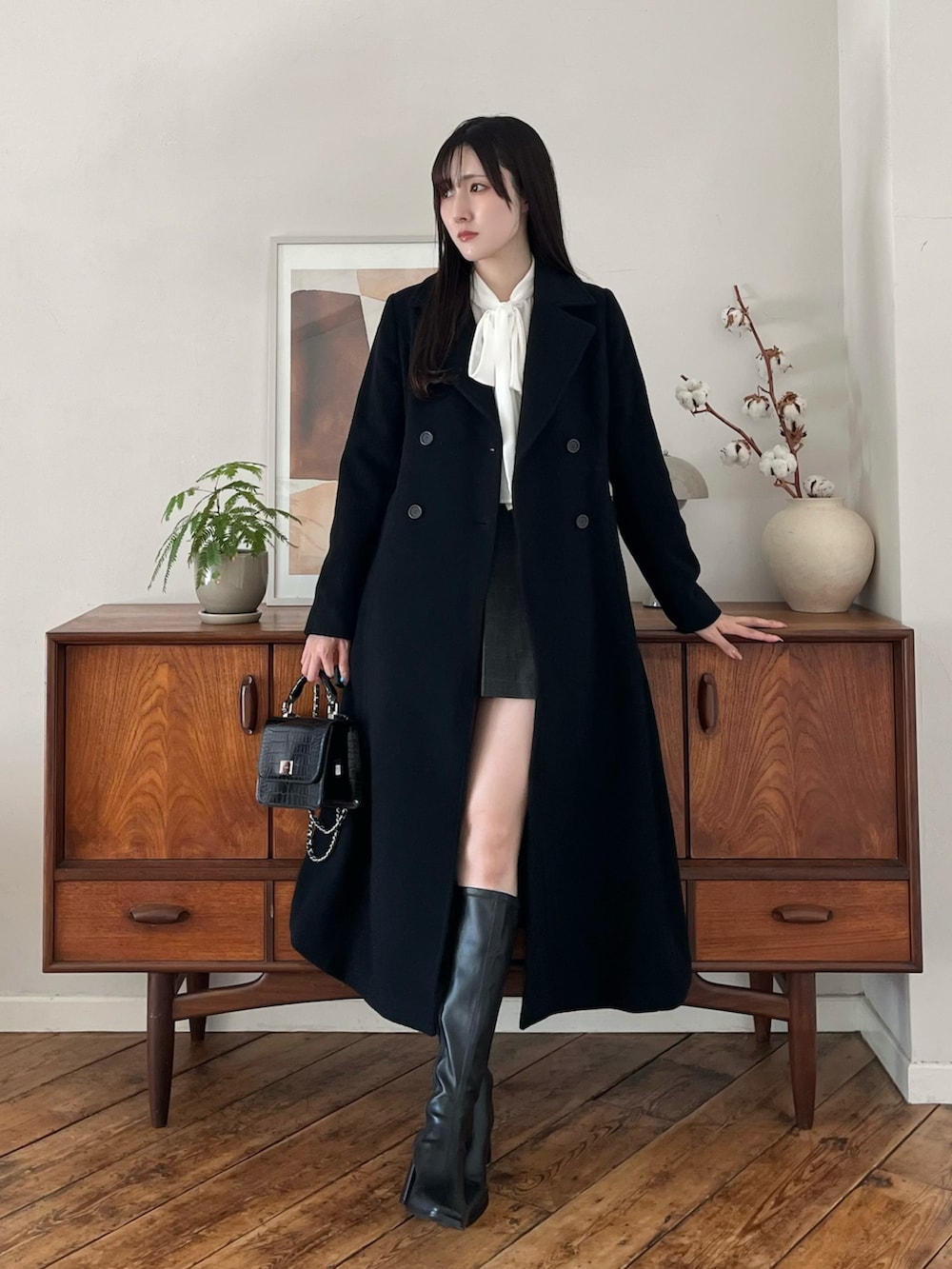 ブラウン系のブーツ、ブラック系のその他アウター、ホワイト系のシャツ/ブラウスを着用したレディースの冬コーディネートの2枚目の写真