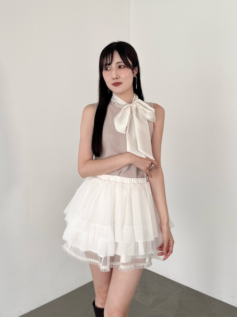 ホワイト系のスカート、ピンク系のニット/セーター、ブラウン系のブーツを着用したレディースの夏コーディネートの8枚目の写真
