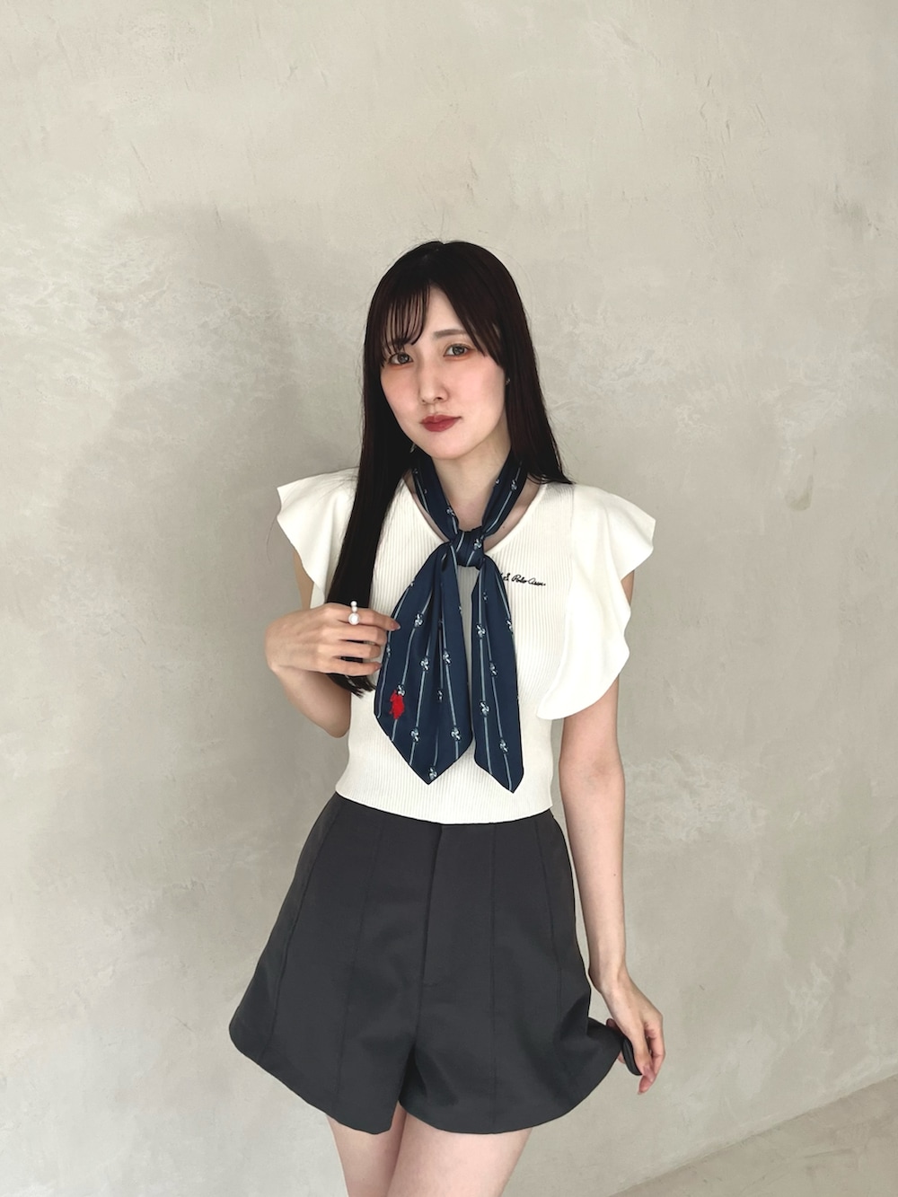 グレー系のその他パンツ、ブラック系のシューズ、ホワイト系のニット/セーターを着用したレディースの夏コーディネートの7枚目の写真