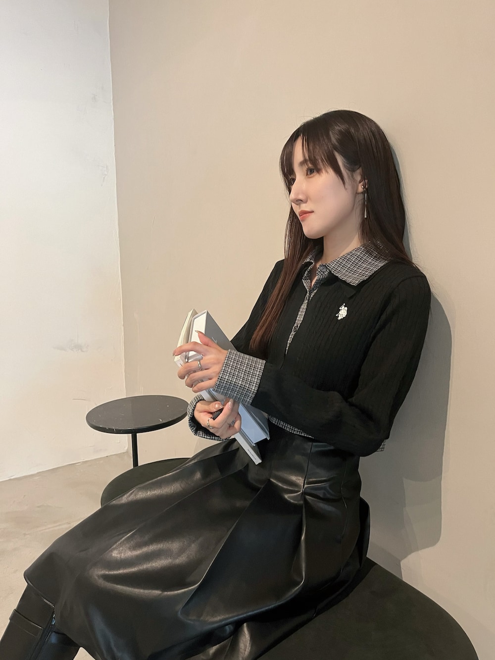 ブラック系のスカート、ブラック系のカーディガン/ボレロ、ブラック系のブーツを着用したレディースの秋コーディネートの4枚目の写真