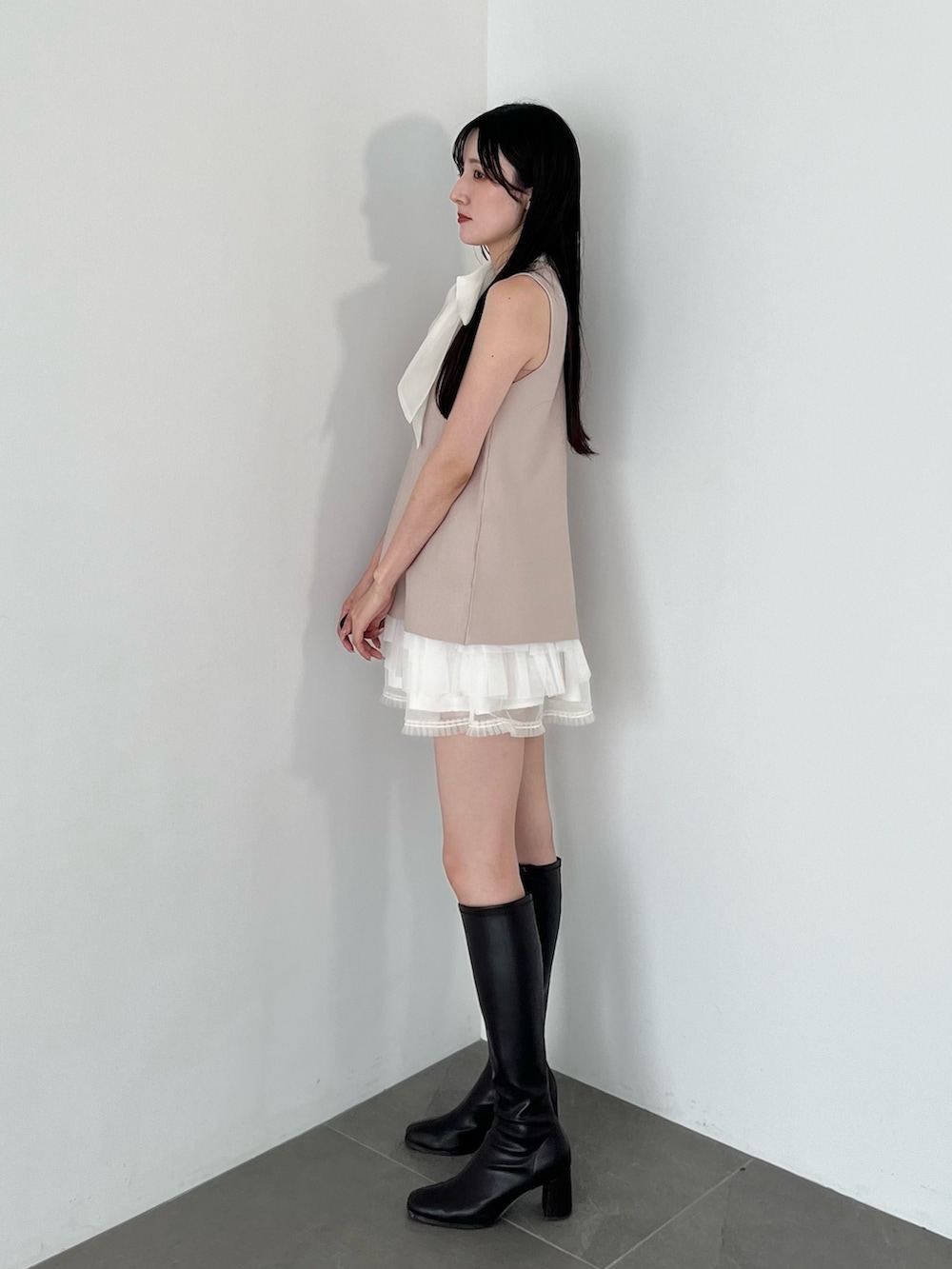 ホワイト系のスカート、ピンク系のニット/セーター、ブラウン系のブーツを着用したレディースの夏コーディネートの2枚目の写真