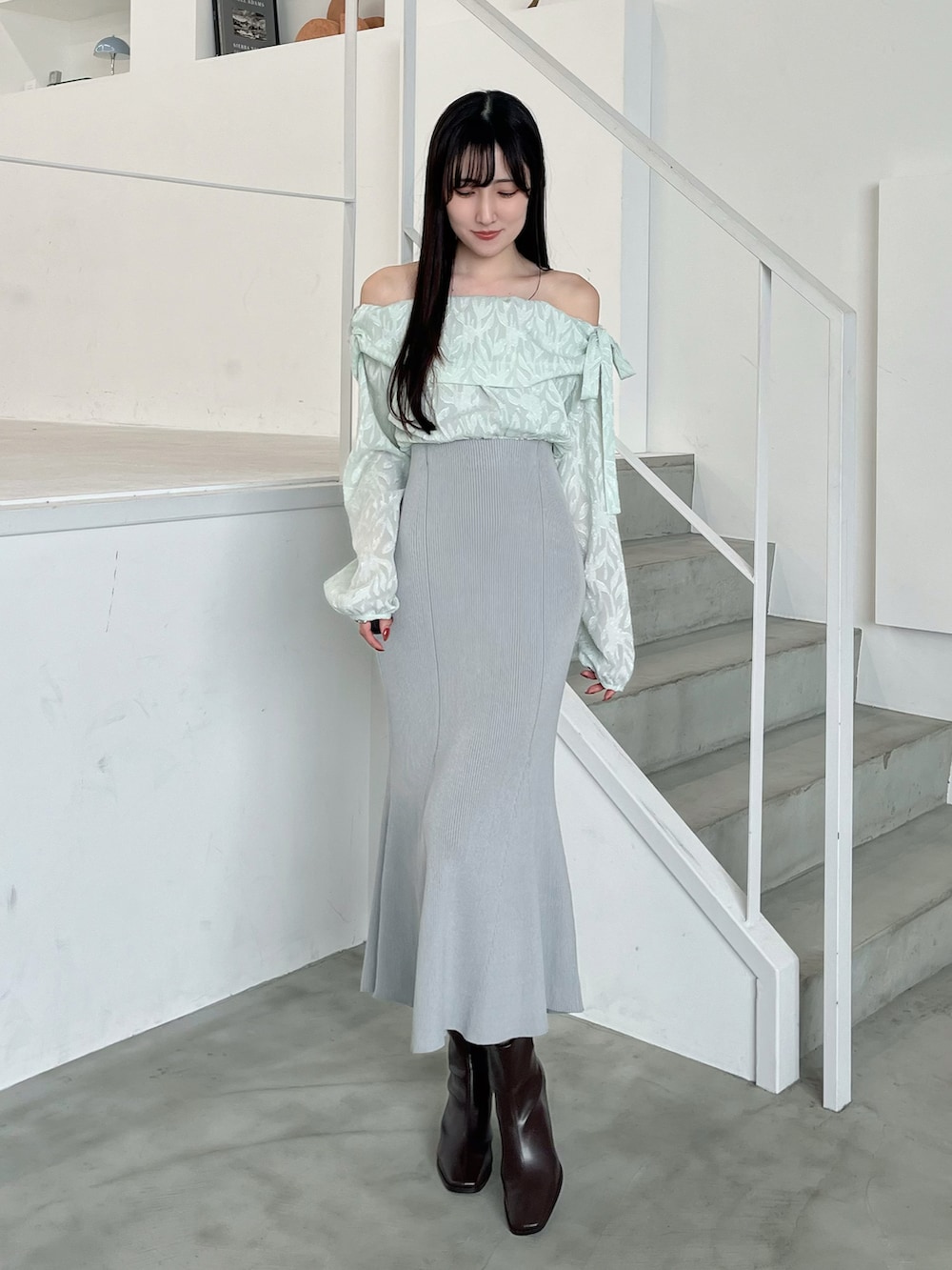 ブラウン系のブーツ、ホワイト系のトレンチコート、グリーン系のワンピースを着用したレディースの春コーディネートの4枚目の写真