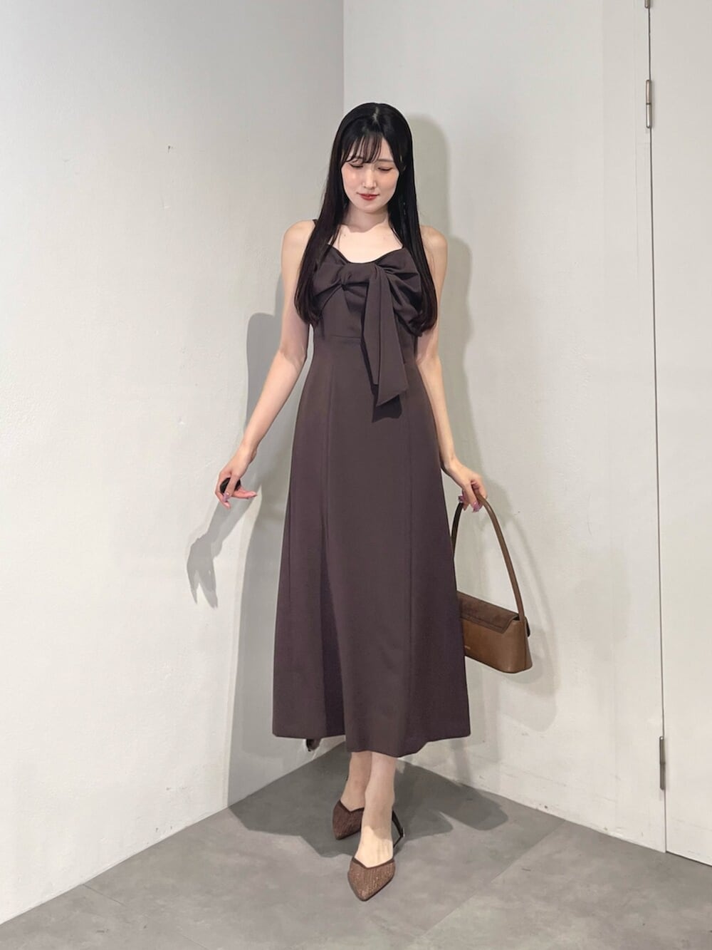 ブラウン系のハンドバッグ、ブラウン系のパンプス、ブラック系のカーディガン/ボレロを着用したレディースの夏コーディネートの7枚目の写真