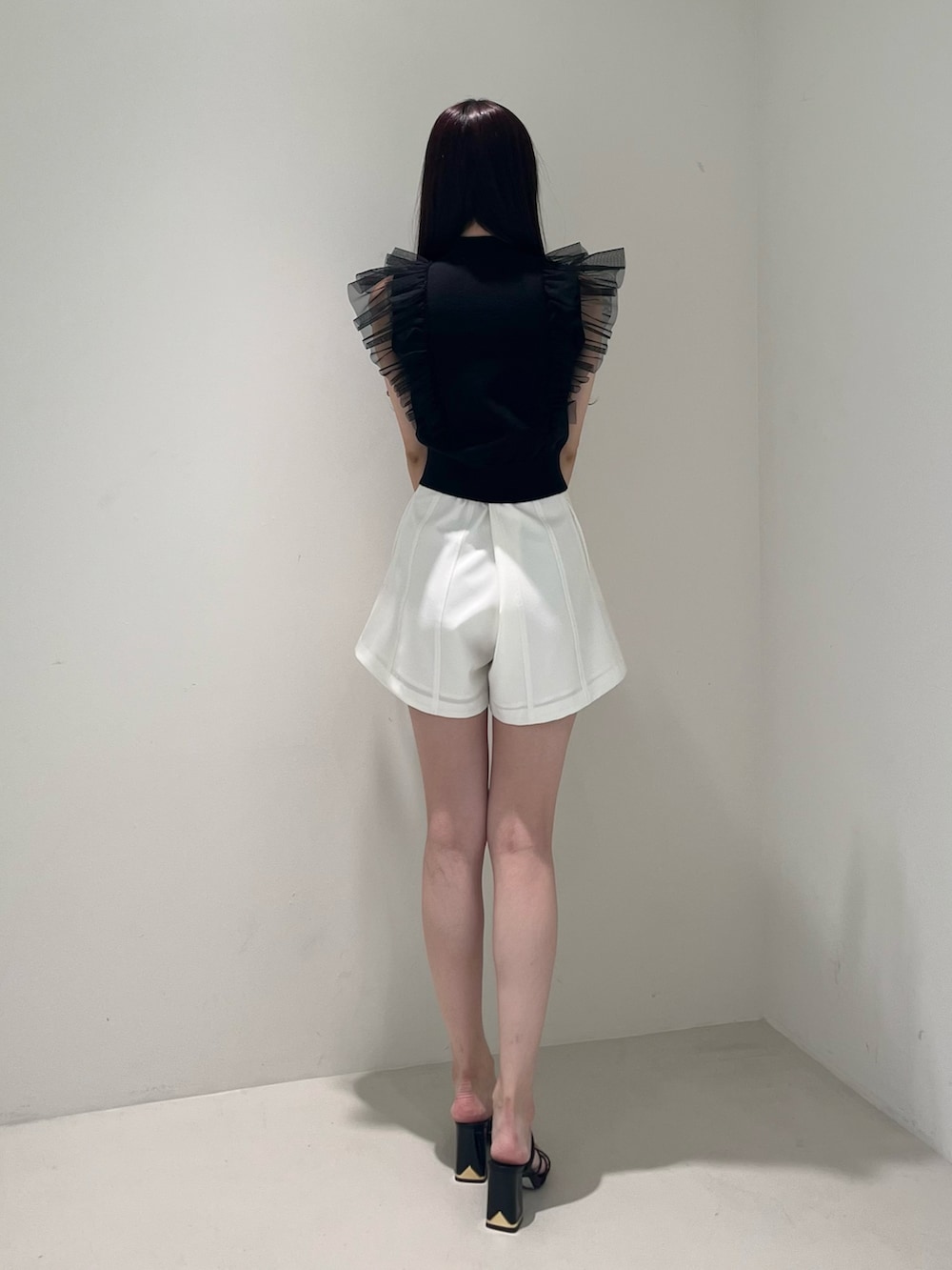 ブラック系のサンダル、ホワイト系のその他パンツ、ブラック系のニット/セーターを着用したレディースの春コーディネートの4枚目の写真