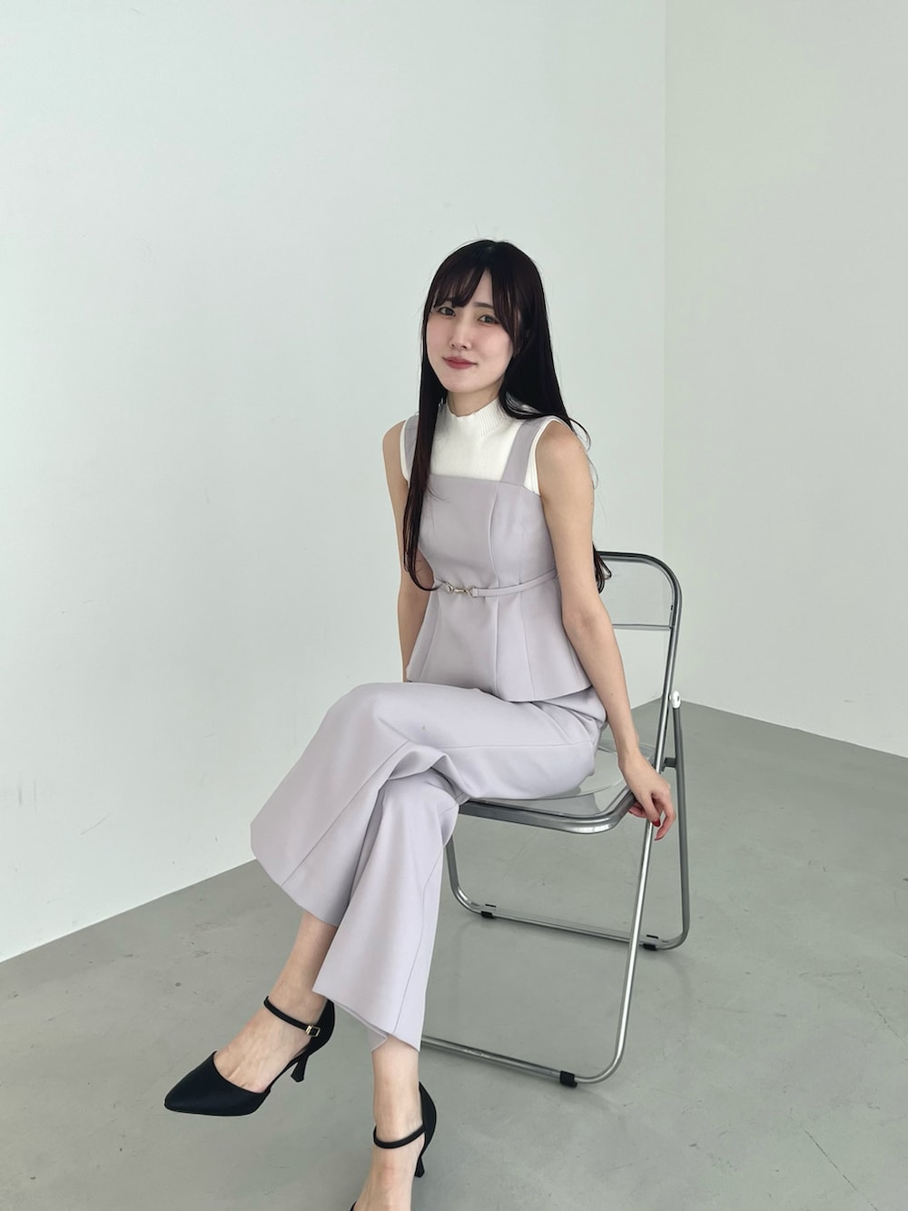ブラック系のパンプス、グレー系のつなぎ/オールインワン、ホワイト系のニット/セーターを着用したレディースの春コーディネートの4枚目の写真