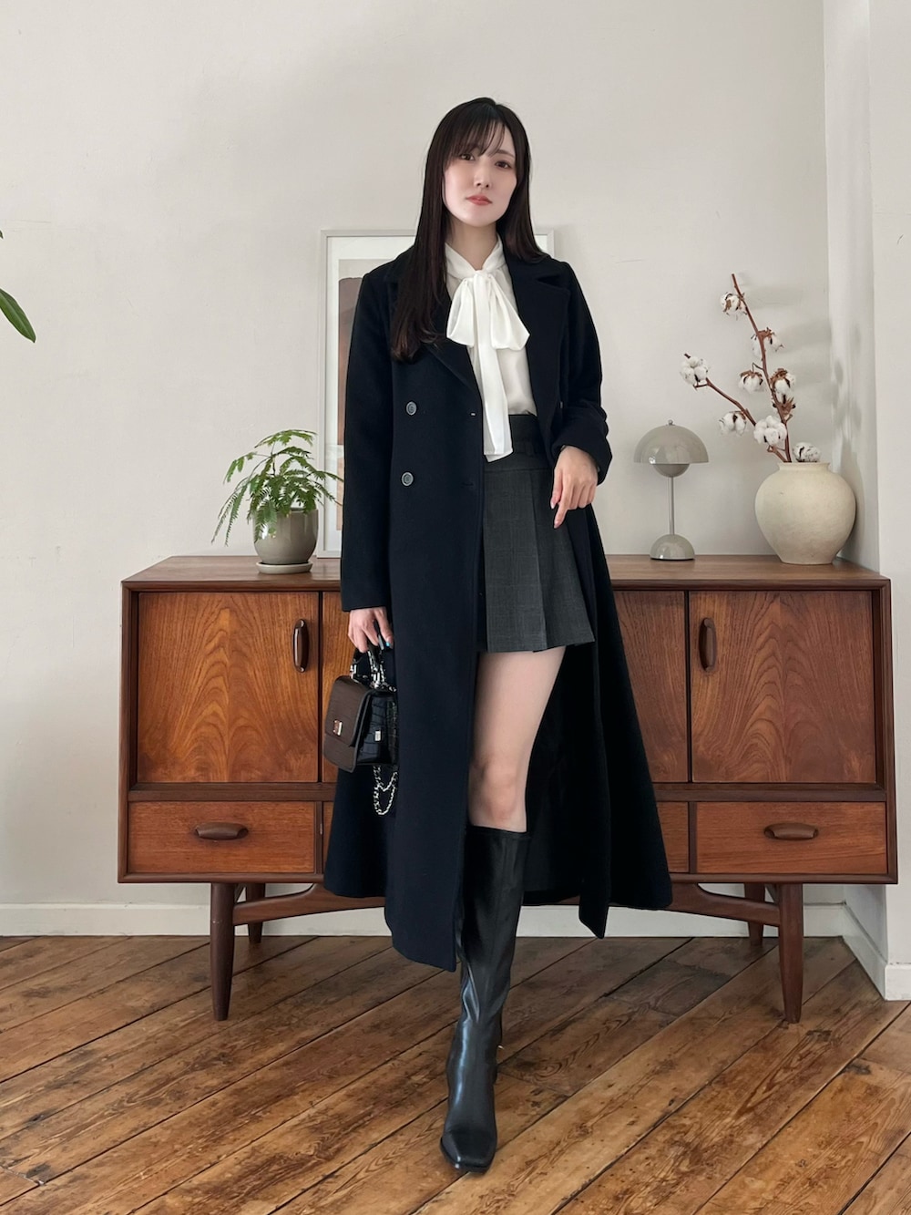 ブラウン系のブーツ、ブラック系のその他アウター、ホワイト系のシャツ/ブラウスを着用したレディースの冬コーディネートの3枚目の写真