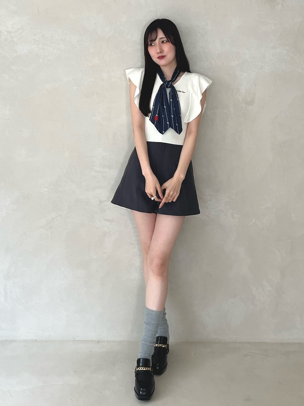 グレー系のその他パンツ、ブラック系のシューズ、ホワイト系のニット/セーターを着用したレディースの夏コーディネートの2枚目の写真