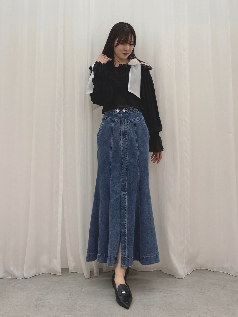 ベージュ系のトレンチコート、ブルー系のスカート、ブラック系のシャツ/ブラウスを着用したレディースの冬コーディネートの5枚目の写真