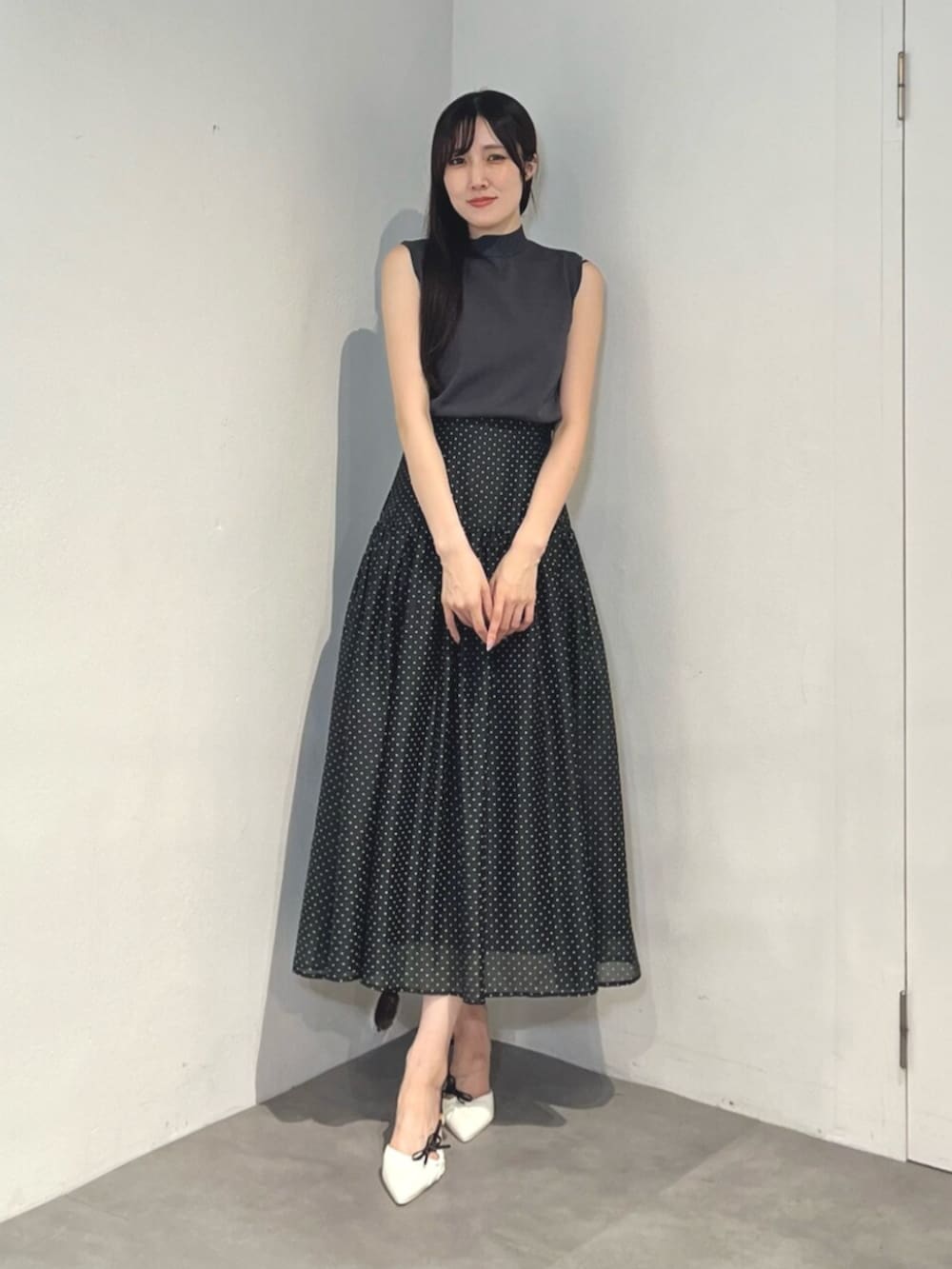 ホワイト系のサンダル、ブラック系のワンピースを着用したレディースの夏コーディネートの2枚目の写真