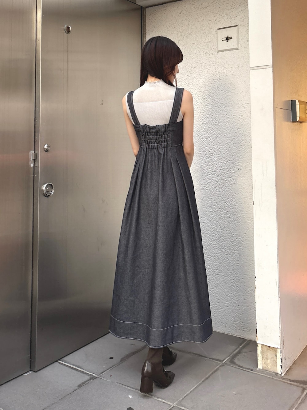 ブルー系のワンピース、ブラウン系のブーツを着用したレディースの秋コーディネートの2枚目の写真