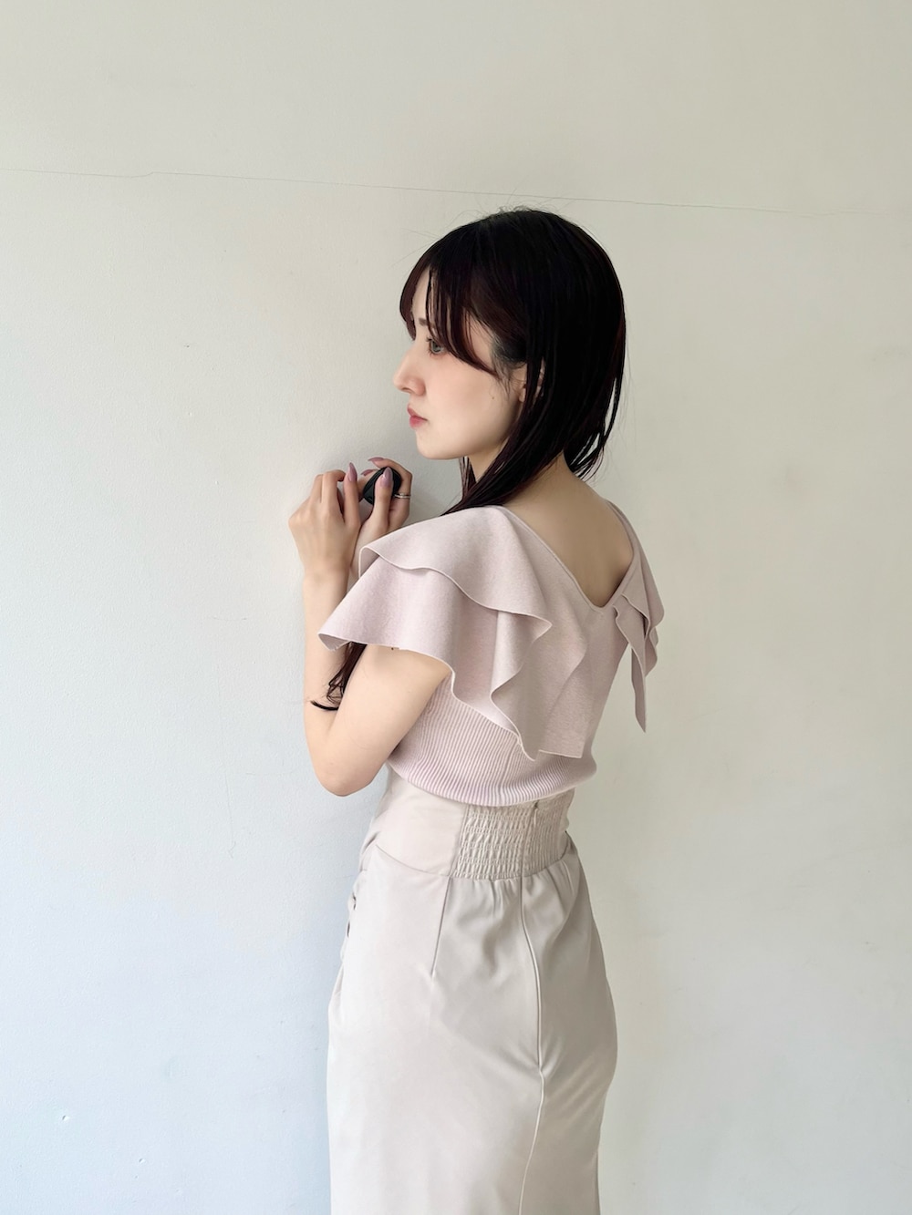 ピンク系のニット/セーター、ブラウン系のサンダル、ベージュ系のスカートを着用したレディースの春コーディネートの5枚目の写真