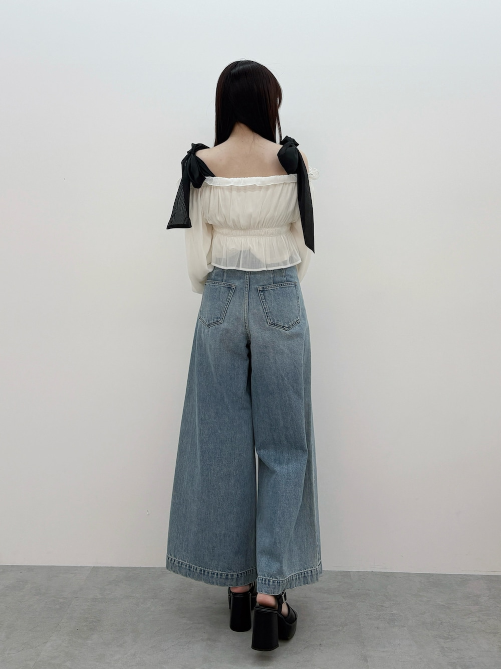 ホワイト系のシャツ/ブラウス、ブルー系のデニムパンツ、ブラック系のサンダルを着用したレディースの春コーディネートの4枚目の写真