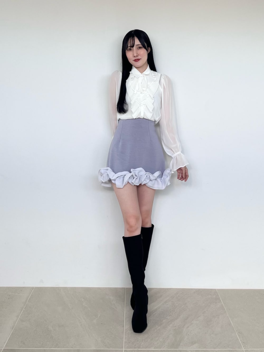 ブラック系のブーツ、ホワイト系のシャツ/ブラウス、ブルー系のスカートを着用したレディースの秋コーディネートの2枚目の写真