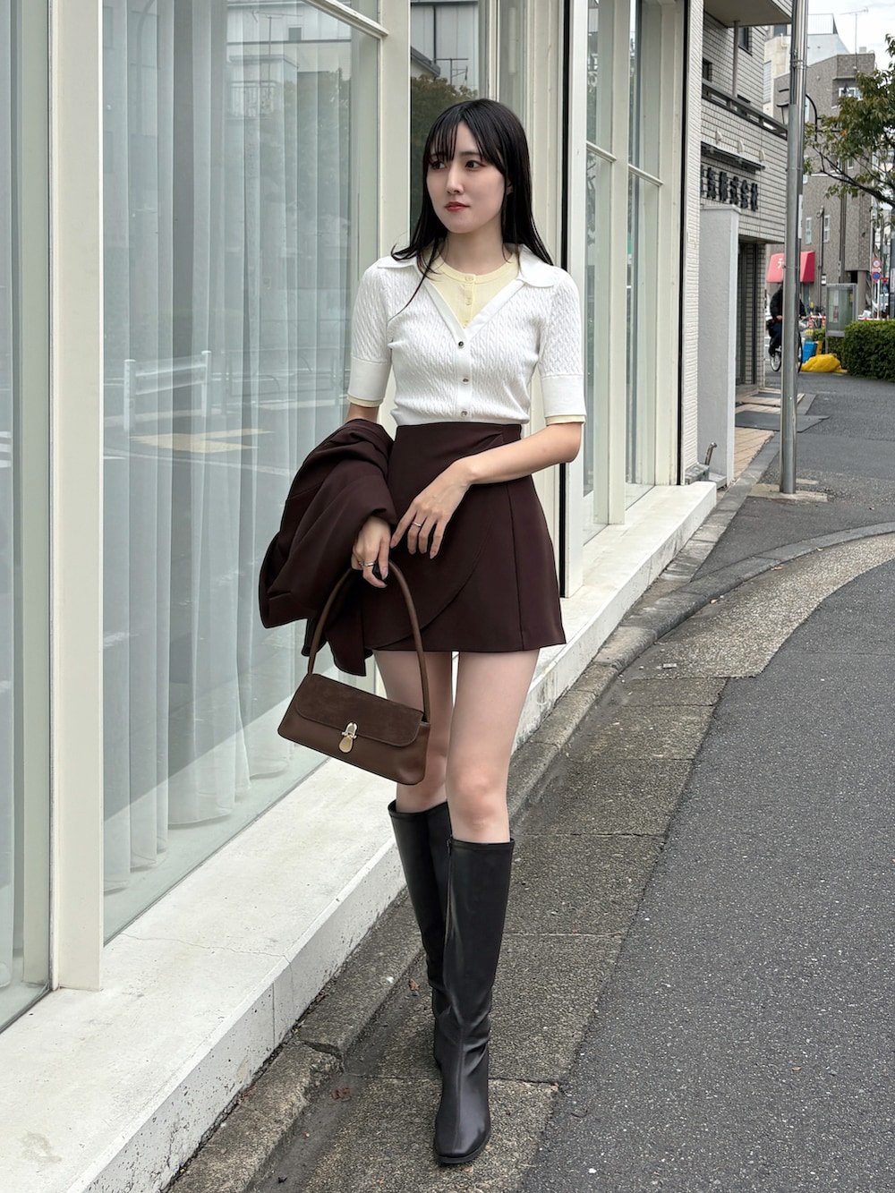 ブラウン系のテーラードジャケット、ホワイト系のニット/セーター、ブラウン系のハンドバッグを着用したレディースの冬コーディネートの3枚目の写真