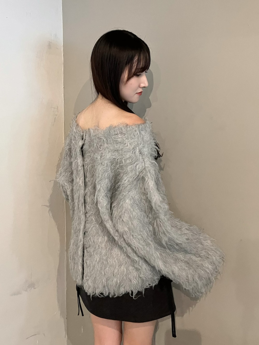 ブラウン系のブーツ、グレー系のニット/セーター、ブラック系のスカートを着用したレディースの冬コーディネートの5枚目の写真