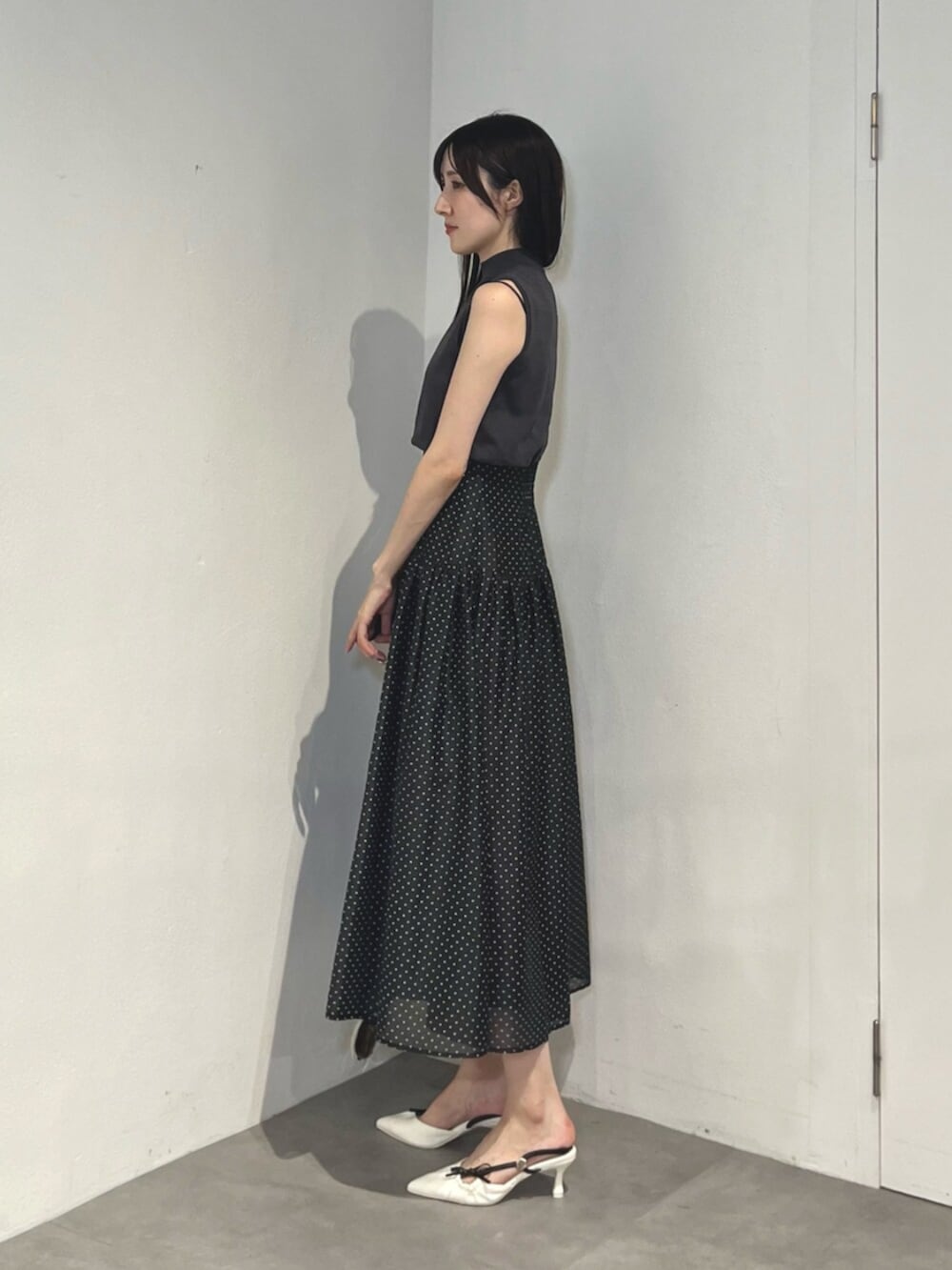 ホワイト系のサンダル、ブラック系のワンピースを着用したレディースの夏コーディネートの4枚目の写真
