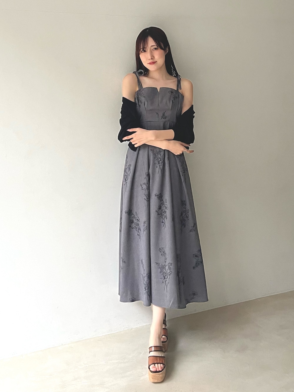 ブラック系のカーディガン/ボレロ、ブラウン系のサンダル、グレー系のワンピースを着用したレディースの春コーディネートの2枚目の写真