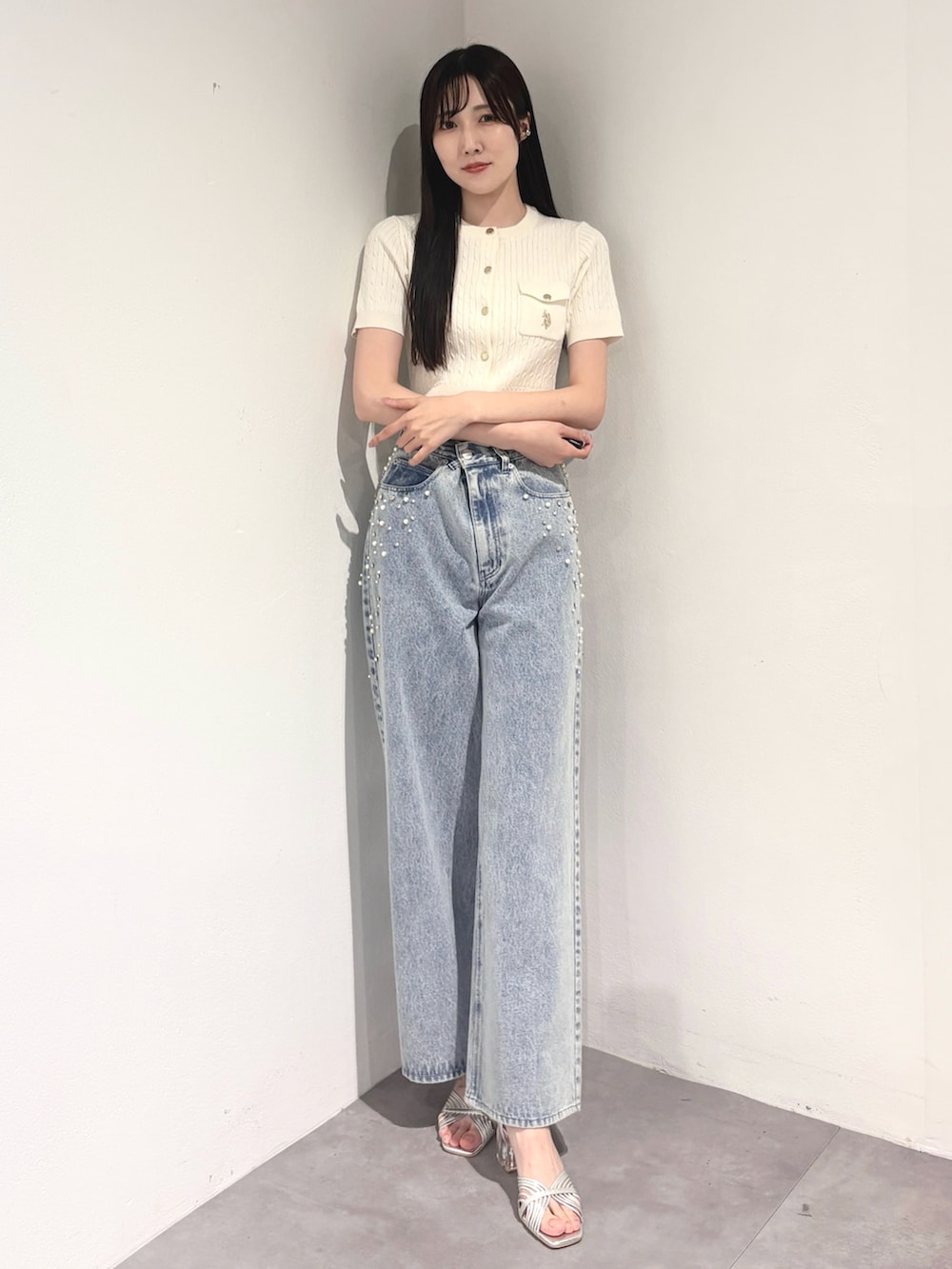 ブルー系のデニムパンツ、シルバー系のサンダル、ホワイト系のカーディガン/ボレロを着用したレディースの夏コーディネートの2枚目の写真
