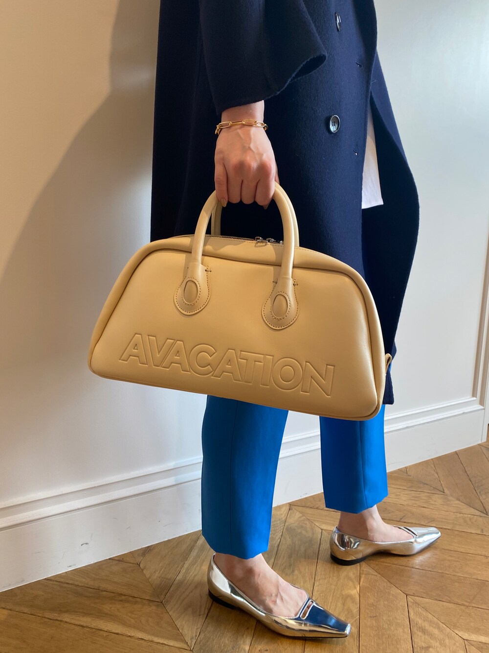 ホワイト系のTシャツ/カットソー、ブルー系のチェスターコート、イエロー系のボストンバッグを着用したレディースの秋コーディネートの4枚目の写真