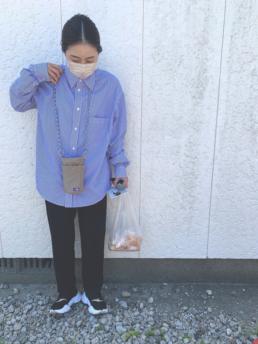 ブラック系のスニーカー、ベージュ系のショルダーバッグを着用したレディースの春コーディネートの2枚目の写真