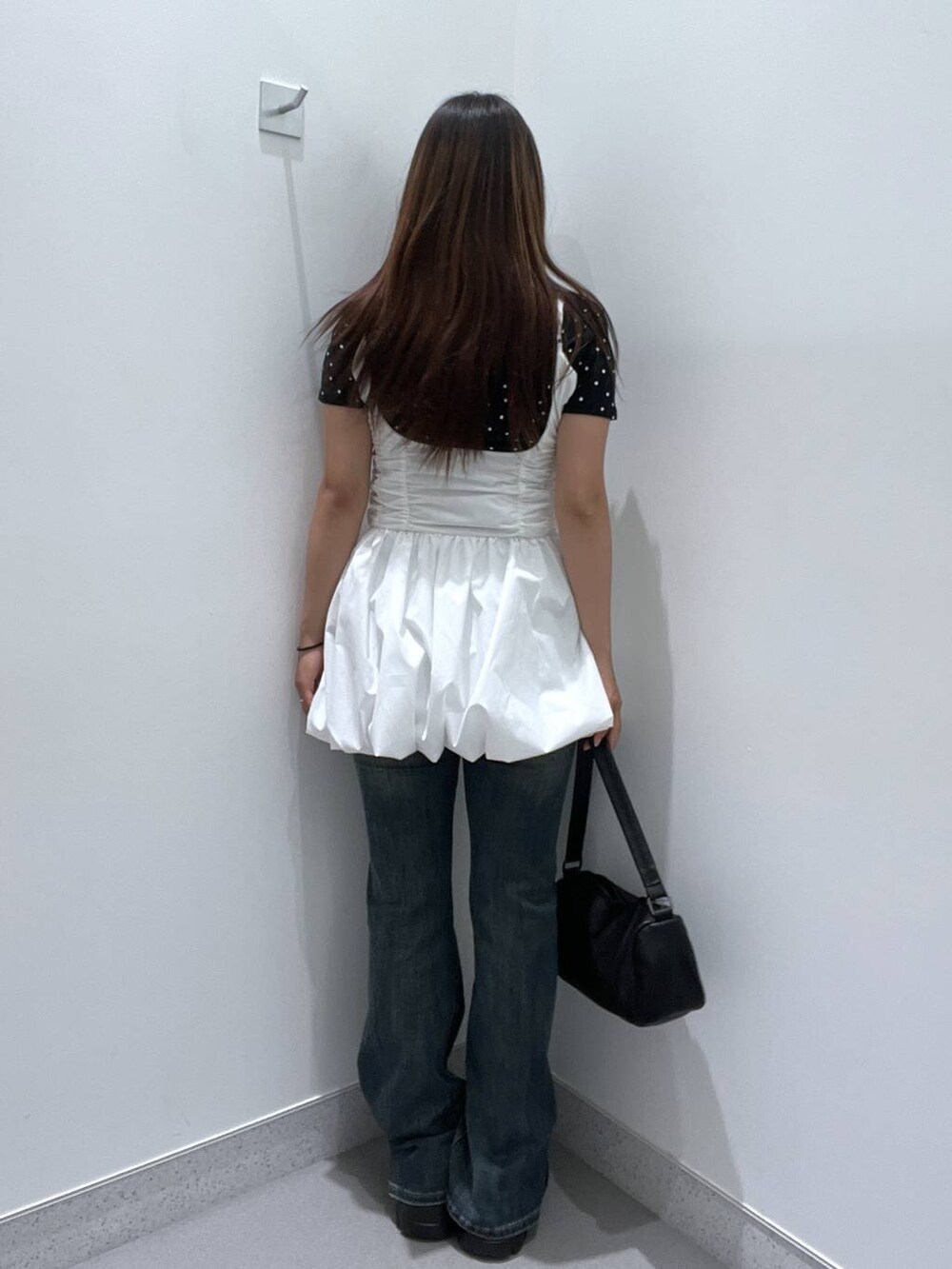ブルー系のデニムパンツ、ホワイト系のワンピース、ブラック系のモカシン/デッキシューズを着用したレディースの夏コーディネートの3枚目の写真