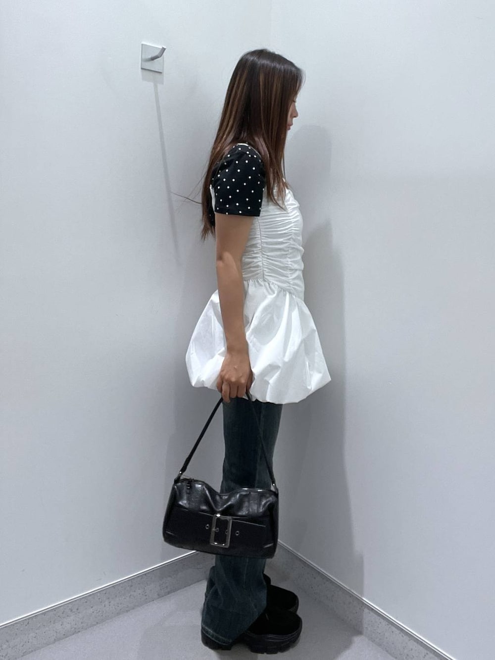 ブルー系のデニムパンツ、ホワイト系のワンピース、ブラック系のモカシン/デッキシューズを着用したレディースの夏コーディネートの2枚目の写真