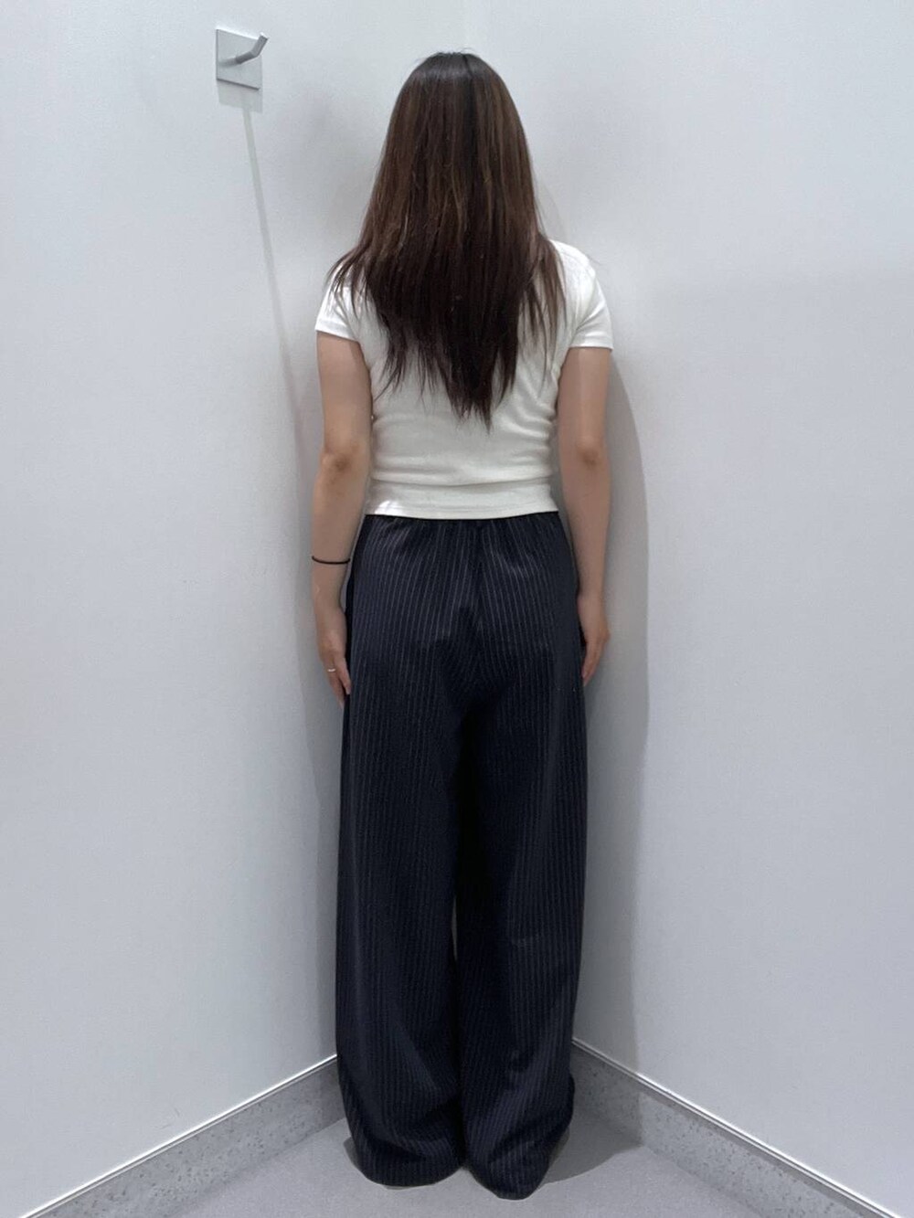 ホワイト系のTシャツ/カットソー、ブルー系のスラックスを着用したレディースの夏コーディネートの3枚目の写真