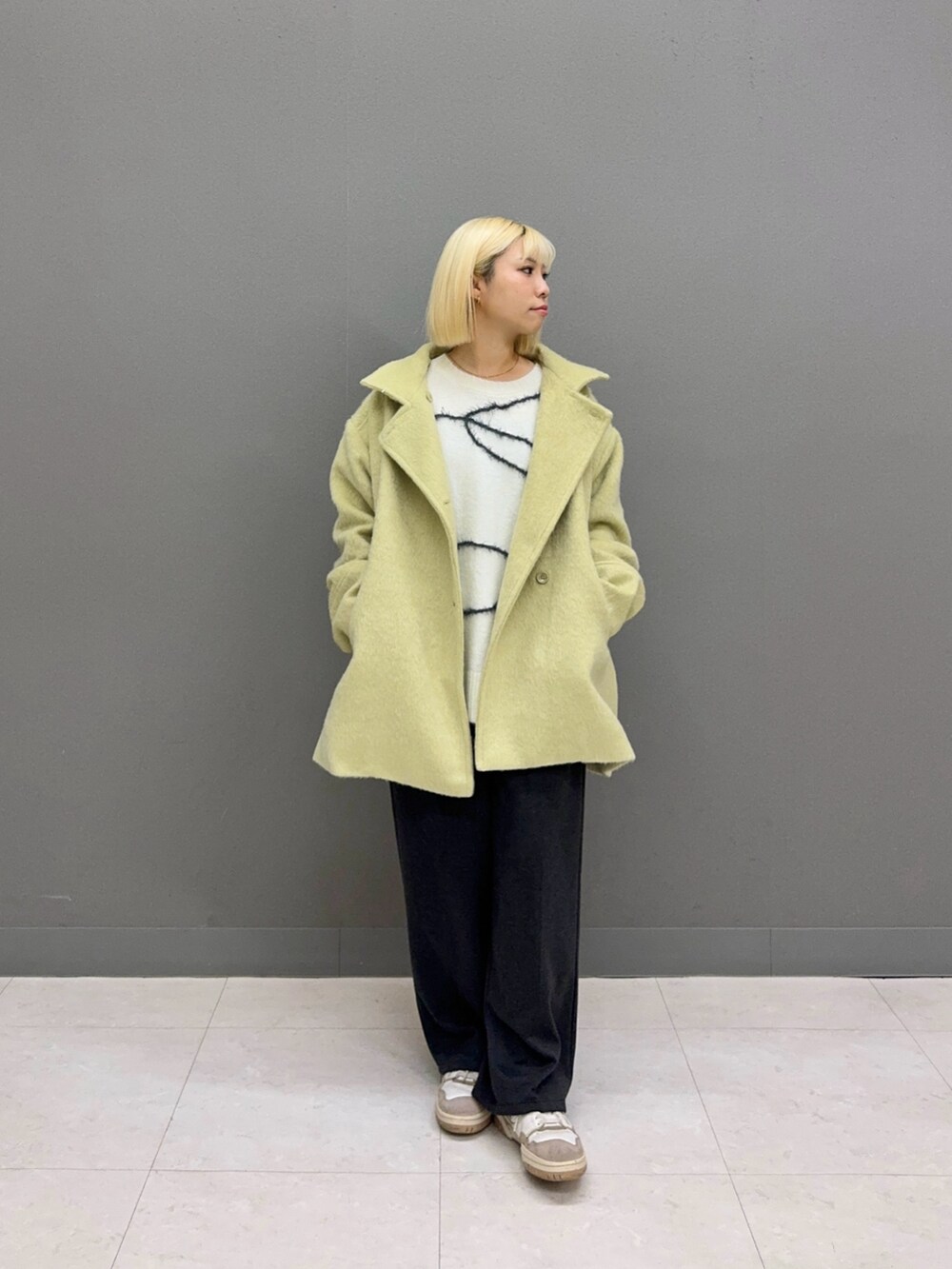 ホワイト系のニット/セーター、グレー系のその他パンツ、ベージュ系のその他アウターを着用したレディースの秋コーディネートの2枚目の写真