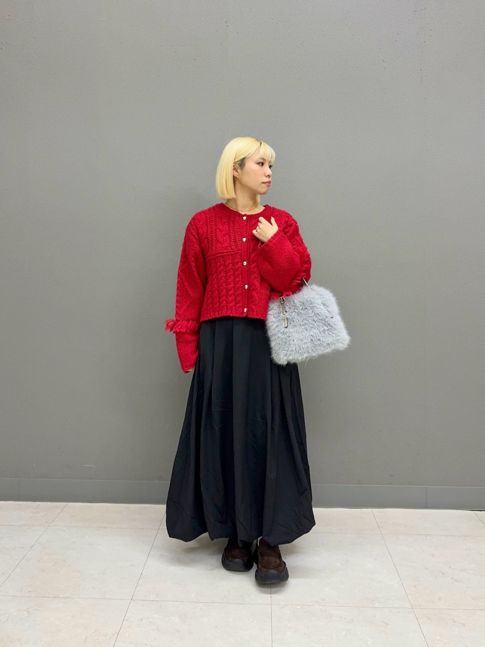 ブラック系のスカート、ブラウン系のカーディガン/ボレロを着用したレディースの秋コーディネートの2枚目の写真