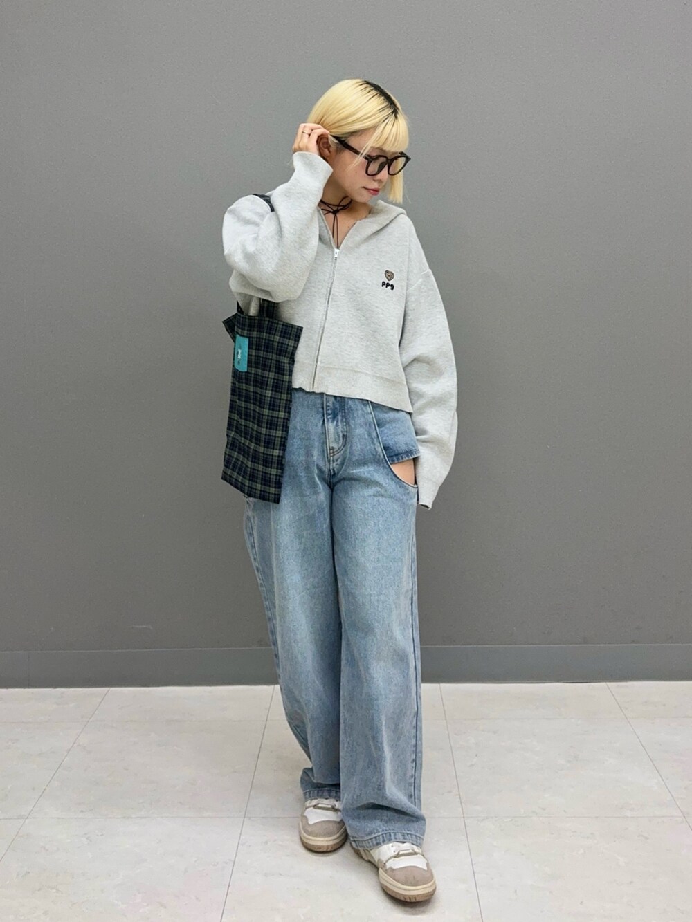 ブルー系のデニムパンツ、グレー系のニット/セーター、ブルー系のトートバッグを着用したレディースの秋コーディネートの2枚目の写真