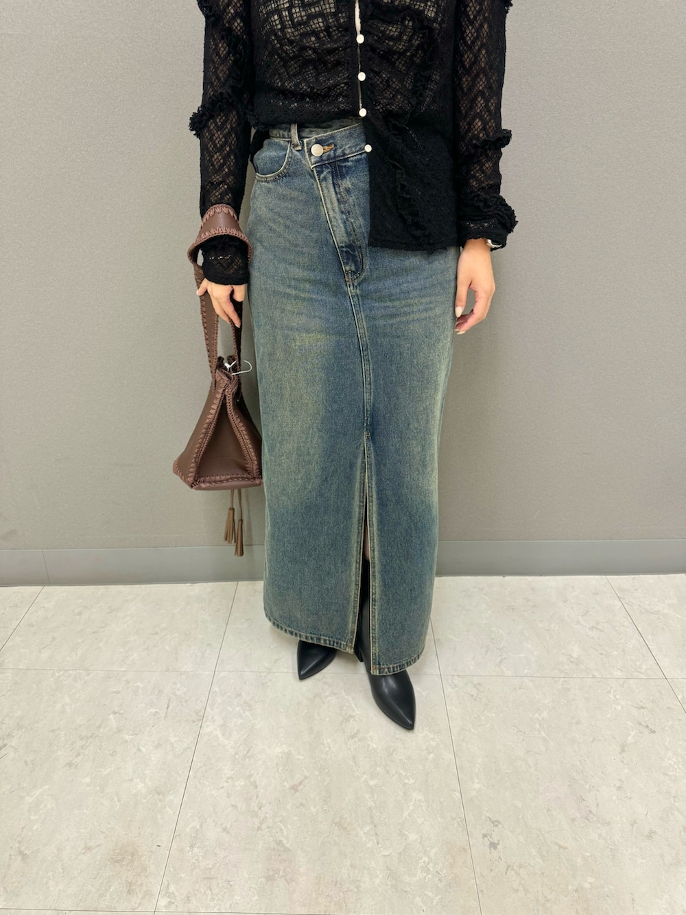 ブラック系のブーツ、ブラウン系のショルダーバッグ、ブラック系のカーディガン/ボレロを着用したレディースの秋コーディネートの2枚目の写真