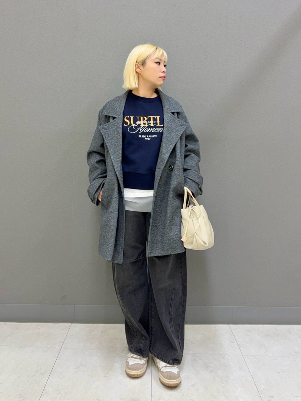 グレー系のデニムパンツ、ブルー系のスウェット、ホワイト系のTシャツ/カットソーを着用したレディースの秋コーディネートの2枚目の写真
