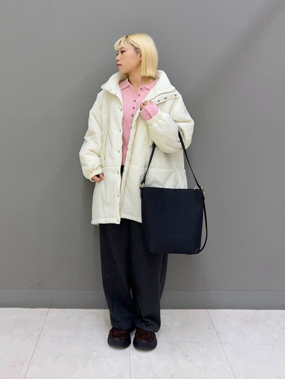 グレー系のその他パンツ、ピンク系のニット/セーター、ホワイト系のダウンジャケット/コートを着用したレディースの秋コーディネートの2枚目の写真