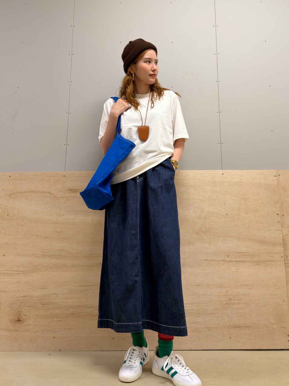 ホワイト系のスニーカー、ブルー系のスカート、ホワイト系のTシャツ/カットソーを着用したレディースの夏コーディネートの2枚目の写真