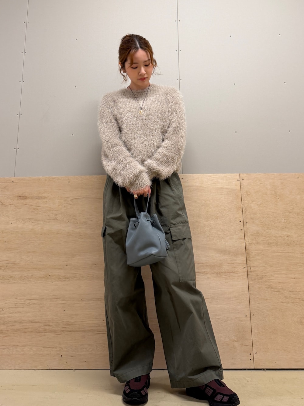 グレー系のニット/セーター、グリーン系のその他パンツ、ブラック系のショルダーバッグを着用したレディースの冬コーディネートの2枚目の写真