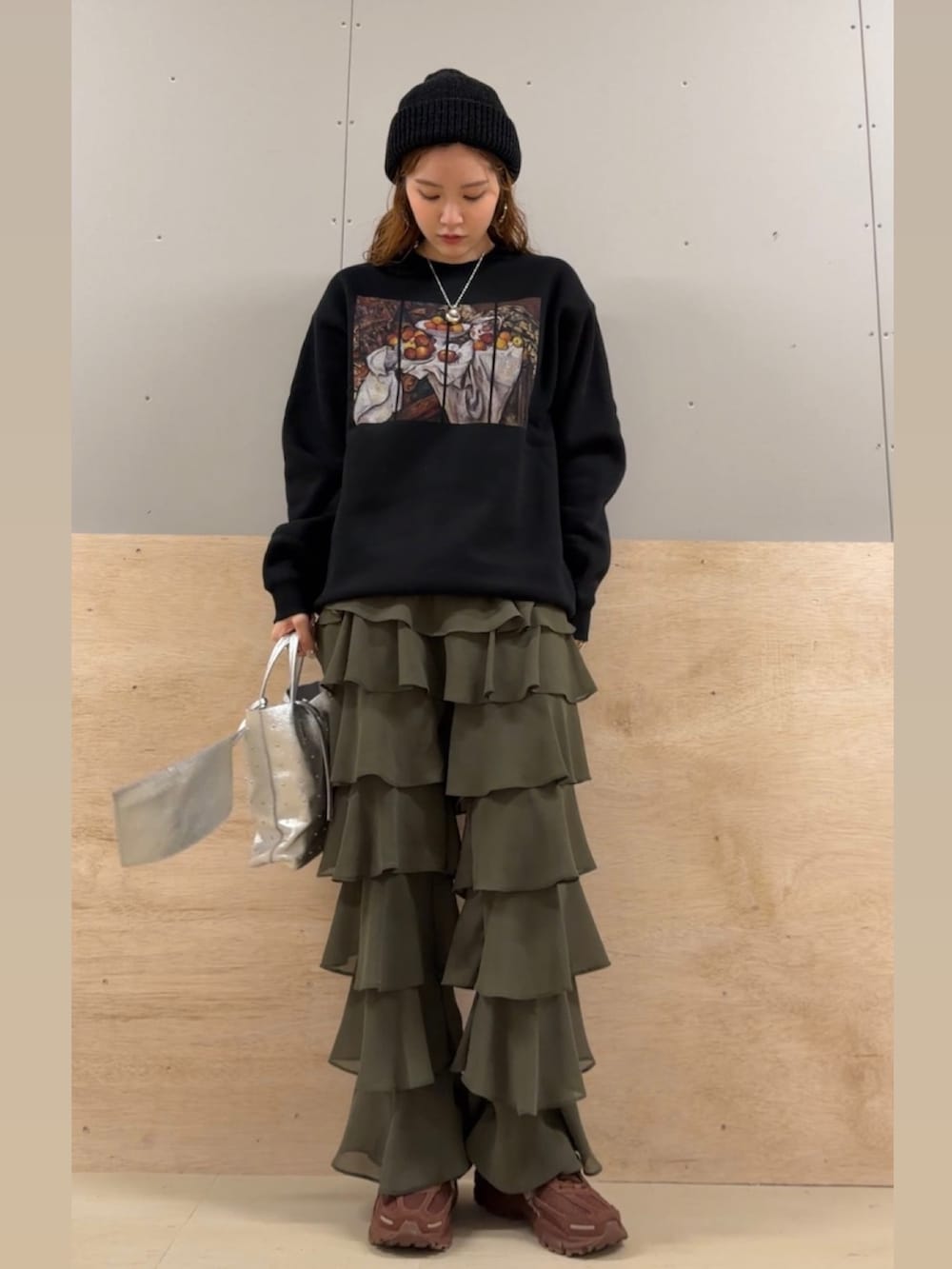 ブラック系のスウェット、シルバー系のトートバッグ、グリーン系のその他パンツを着用したレディースの冬コーディネートの2枚目の写真