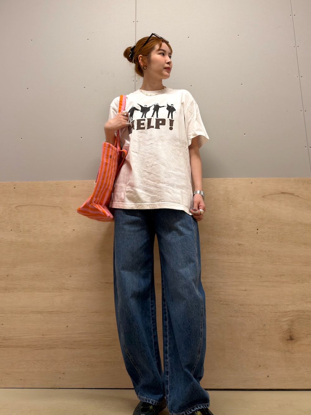 ピンク系のトートバッグ、ホワイト系のTシャツ/カットソー、ブルー系のデニムパンツを着用したレディースの春コーディネートの2枚目の写真