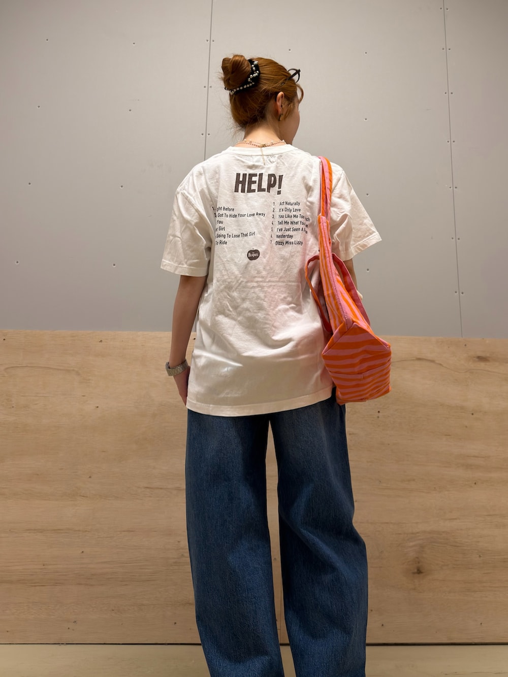 ピンク系のトートバッグ、ホワイト系のTシャツ/カットソー、ブルー系のデニムパンツを着用したレディースの春コーディネートの3枚目の写真