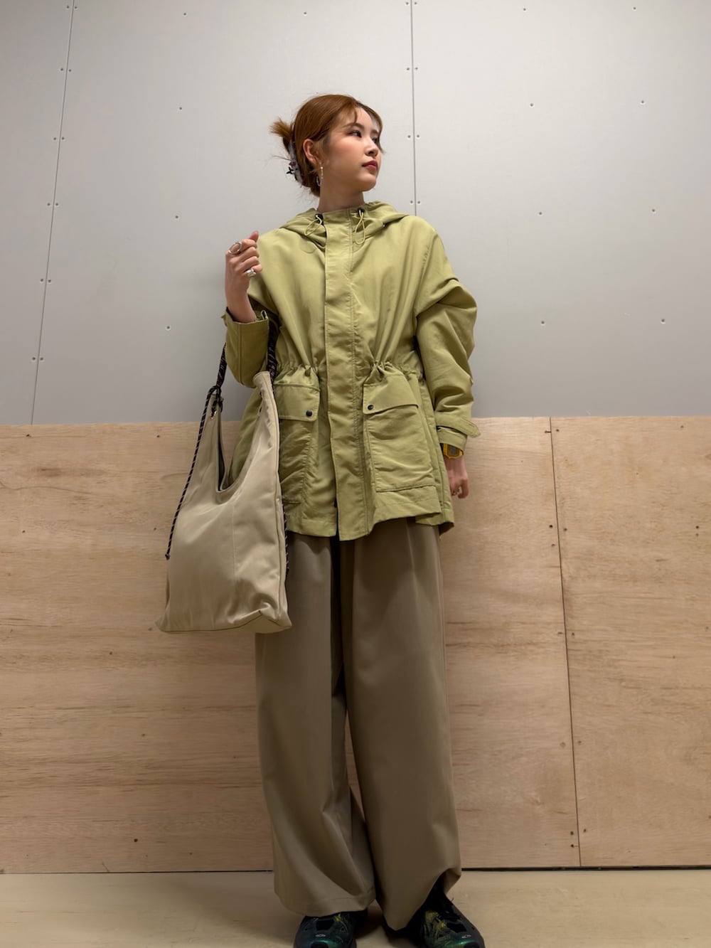 ベージュ系のトートバッグ、ベージュ系のその他パンツ、グリーン系のマウンテンパーカーを着用したレディースの春コーディネートの3枚目の写真