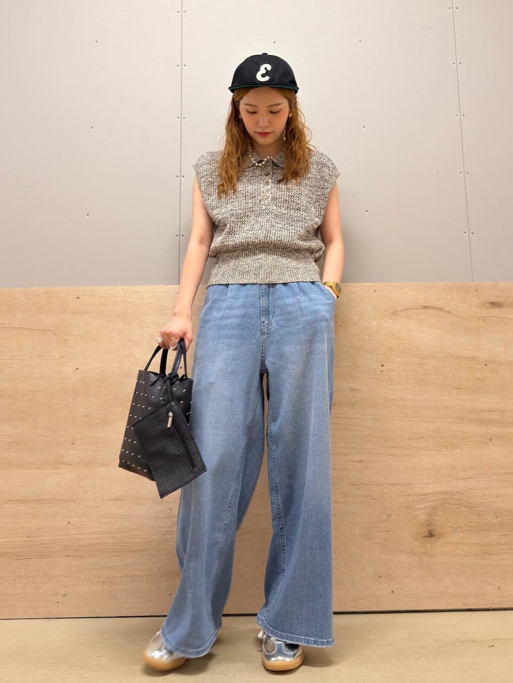 ブルー系のデニムパンツ、シルバー系のスニーカー、ブラック系のニット/セーターを着用したレディースの夏コーディネートの2枚目の写真