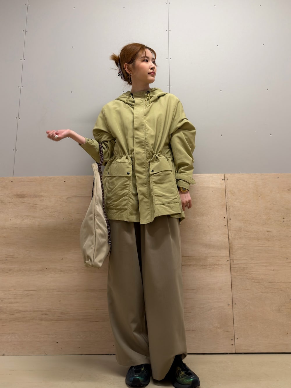 ベージュ系のトートバッグ、ベージュ系のその他パンツ、グリーン系のマウンテンパーカーを着用したレディースの春コーディネートの2枚目の写真