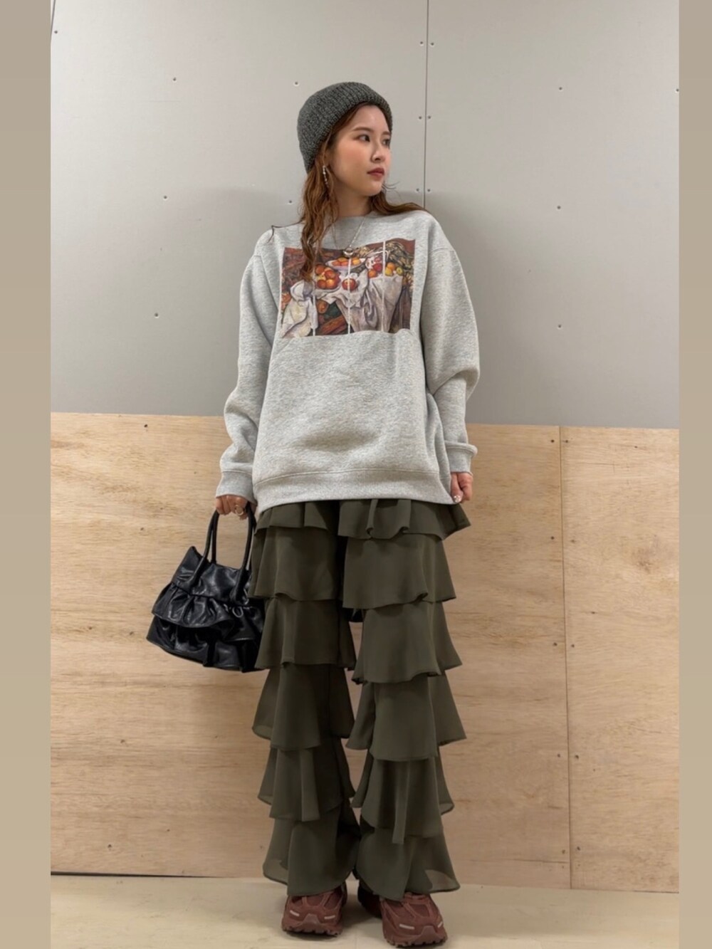 グレー系のスウェット、グリーン系のその他パンツ、ブラック系のハンドバッグを着用したレディースの冬コーディネートの2枚目の写真