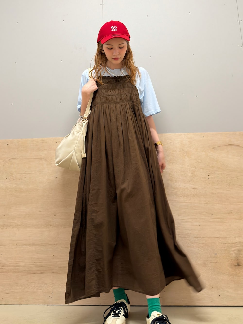 ブルー系のTシャツ/カットソー、ブラウン系のワンピース、ベージュ系のスニーカーを着用したレディースの夏コーディネートの2枚目の写真