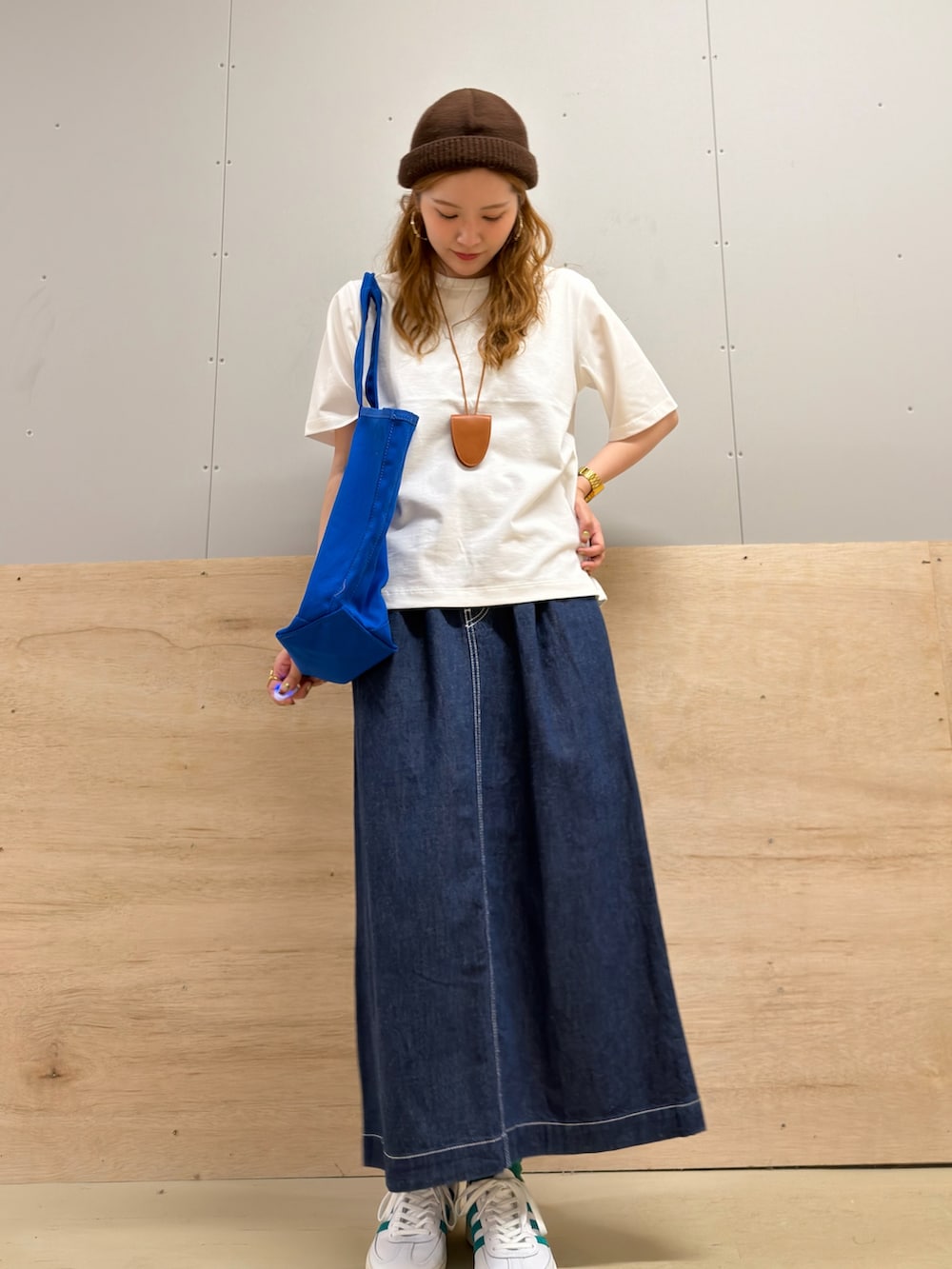ホワイト系のスニーカー、ブルー系のスカート、ホワイト系のTシャツ/カットソーを着用したレディースの夏コーディネートの3枚目の写真